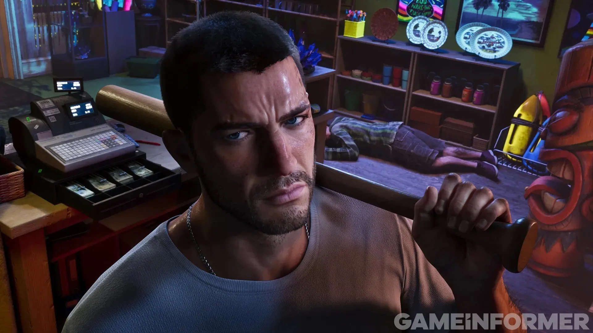 GTA 6 screenshot from Game Informer — Jason with a baseball bat on his shoulder in a looted shop, a man on the floor behind him