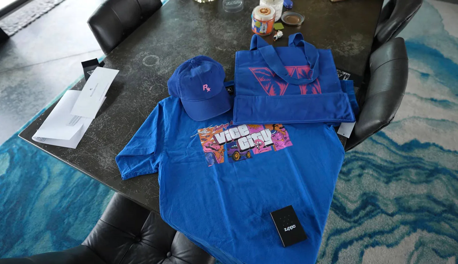 Contents of Rockstar's GTA 6 creator merch pack: blue 'Greetings from Vice City' T-shirt, blue cap with a pink R* logo, blue tote bag with a pink VI logo and a boxed Zippo lighter (creator's photo)