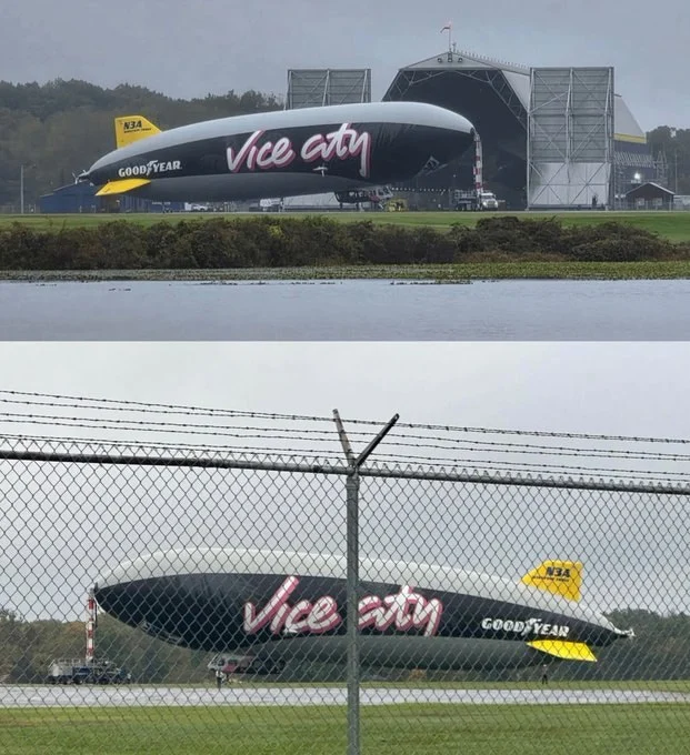 Two photos of the Goodyear blimp in the Vice City livery on the ground outside its hangar, seen across water and through a fence
